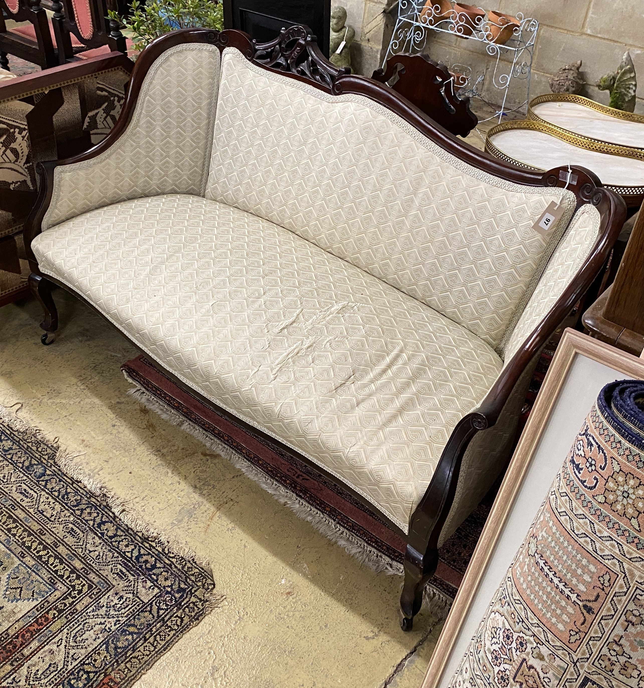 A late Victorian carved mahogany upholstered settee, length 140cm, depth 54cm, height 90cm